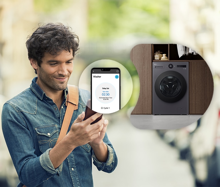 The man is looking at the smartphone and is showing the screen and washing machine image of the smartphone next to him